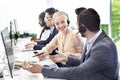 Smiling customer support workers communicating to solve client`s problem together at call centre office Royalty Free Stock Photo