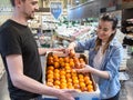 Smiling customers buying sicilian oranges in grocery section Royalty Free Stock Photo