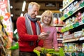 Smiling customers senior couple doing grocery in supermarket Royalty Free Stock Photo