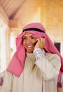 Smiling cute arabian man using his cellphone