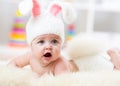 Smiling cute baby in bunny costume lying on fur in nursery Royalty Free Stock Photo