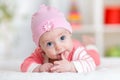 Smiling cute baby lying on her tummy in nursery room Royalty Free Stock Photo