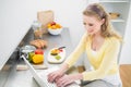 Smiling cute blonde typing on her laptop Royalty Free Stock Photo