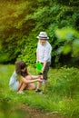 Smiling cute girl and blond boy cleaning horticultura tools in garden on sunny day. Happy childhood. Summer activities Royalty Free Stock Photo