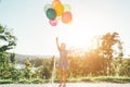 Smiling cute girl holding colorful balloons in the city park Royalty Free Stock Photo