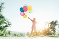 Smiling cute girl holding colorful balloons in the city park Royalty Free Stock Photo