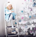 Smiling cute girl posing beside a decorated Christmas tree