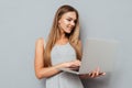 Smiling cute girl standing and using laptop Royalty Free Stock Photo