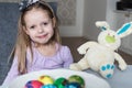 Smiling cute kid with easter eggs and plush bunny. Easter