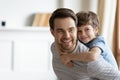 Overjoyed little boy piggyback play with young dad Royalty Free Stock Photo