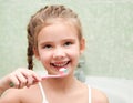 Smiling cute little girl brushing teeth in bathroom Royalty Free Stock Photo