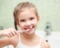 Smiling cute little girl brushing teeth in bathroom Royalty Free Stock Photo
