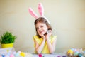 Cute girl in bunnies ears holds easter egg in hand while looking at camera. preparing for Easter Royalty Free Stock Photo