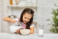 Cute little girl eating breakfast: cereal with the milk Royalty Free Stock Photo