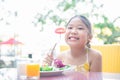 Smiling cute little girl eating fresh tomato and salad Royalty Free Stock Photo