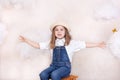 A smiling cute little girl flies in the sky with clouds and stars. Little astrologer Little traveler. The concept of preschool edu Royalty Free Stock Photo