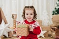 Smiling cute little girl at home during christmas time holding gift box Royalty Free Stock Photo