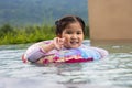 Smiling cute little girl in swimming pool in sunny day Royalty Free Stock Photo