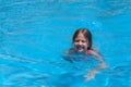 Smiling cute little girl in swimming pool on sunny summer day. Children beach fun Royalty Free Stock Photo