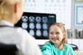 Smiling cute little girl talking to female doctor at her office Royalty Free Stock Photo