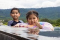 Smiling cute little son and daughter in swimming pool in sunny day Royalty Free Stock Photo