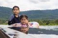 Smiling cute little son and daughter in swimming pool in sunny day Royalty Free Stock Photo