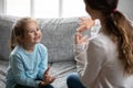 Smiling cute small disabled deaf child girl learning sign language.