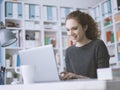 Smiling student girl connecting with a laptop