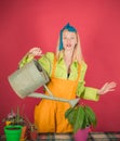 Smiling cute woman in green shirt has grown beautiful flower. Free time leisure. Beautiful blonde girl with colorful Royalty Free Stock Photo