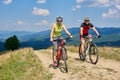 Smiling cyclists couple man and woman in sportswear and helmets cycling cross country bikes Royalty Free Stock Photo