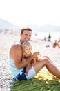 Smiling dad feeding his little daughter on the beach Royalty Free Stock Photo