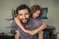 Smiling dad giving his son a piggyback at home Royalty Free Stock Photo