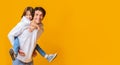 Smiling daddy and daughter posing over yellow background