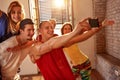 Smiling dancers taking selfie on smartphone while having fun aft