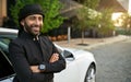 Smiling dapper Arabic Muslim businessman wearing Keffiyeh and arms crossed