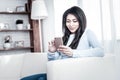 Smiling dark-haired lady spending time with her phone