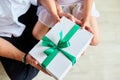 Smiling daughter congratulating dad and giving present on birthday at home, little girl is giving her handsome father a gift box o Royalty Free Stock Photo