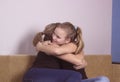 Smiling daughter hugging his mother at home. Concept of couple family is in sorrow. Royalty Free Stock Photo