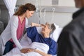 Smiling daughter and son visiting mother in hospital