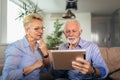 Smiling deaf senior couple talking using sign language on the digital tablet`s cam