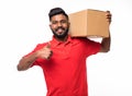 Smiling delivery indian man in blue uniform carrying packages while gesturing thumb up sign isolated on white background Royalty Free Stock Photo