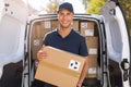 Smiling delivery man loading boxes into his truck Royalty Free Stock Photo