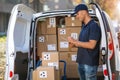 Smiling delivery man loading boxes into his truck Royalty Free Stock Photo