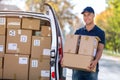 Smiling delivery man loading boxes into his truck Royalty Free Stock Photo