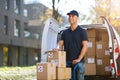 Smiling delivery man loading boxes into his truck Royalty Free Stock Photo