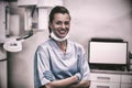 Smiling dental assistant standing with arms crossed