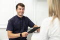 Smiling dentist discuss terms of future work with client. Selective focus