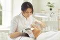 Smiling dermatologist making ultrasound apparatus facial cleaning for young woman Royalty Free Stock Photo