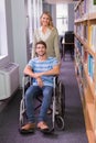 Smiling disabled student with classmate in library Royalty Free Stock Photo