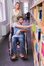 Smiling disabled student with classmate in library Royalty Free Stock Photo